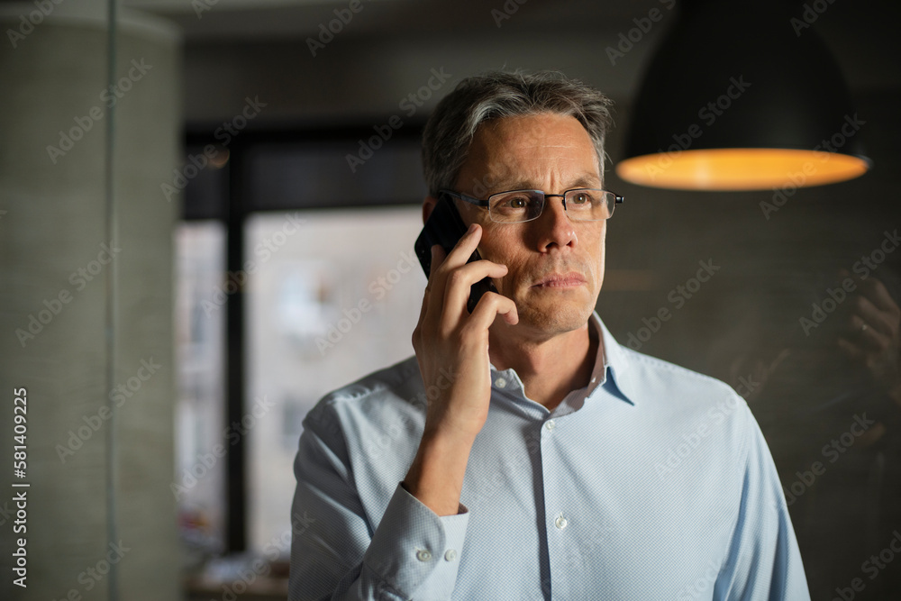 Businessman in office. Handsome man talking on phone at work. Businessman in office. Handsome man talking on phone at work.