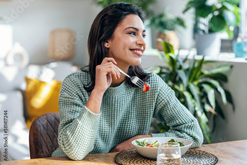 Wallpaper Mural Beautiful smiling woman eating healthy salad at home. Torontodigital.ca