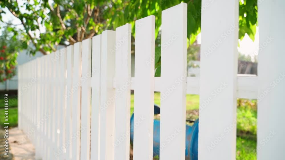 Stylish white wooden fence low on a country lawn, warm sunny weather. Smooth camera movement Stylish white wooden fence low on a country lawn, warm sunny weather. Smooth camera movement