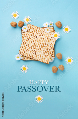 Passover greeting card with matzah, nuts daisy and tulip flowers on blue background.