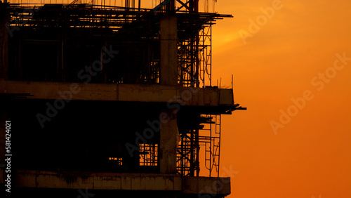 Silhouette construction site on sunset in evening time.Engineer and worker on building site.Construction sites and cranes are working in the industry new building business.