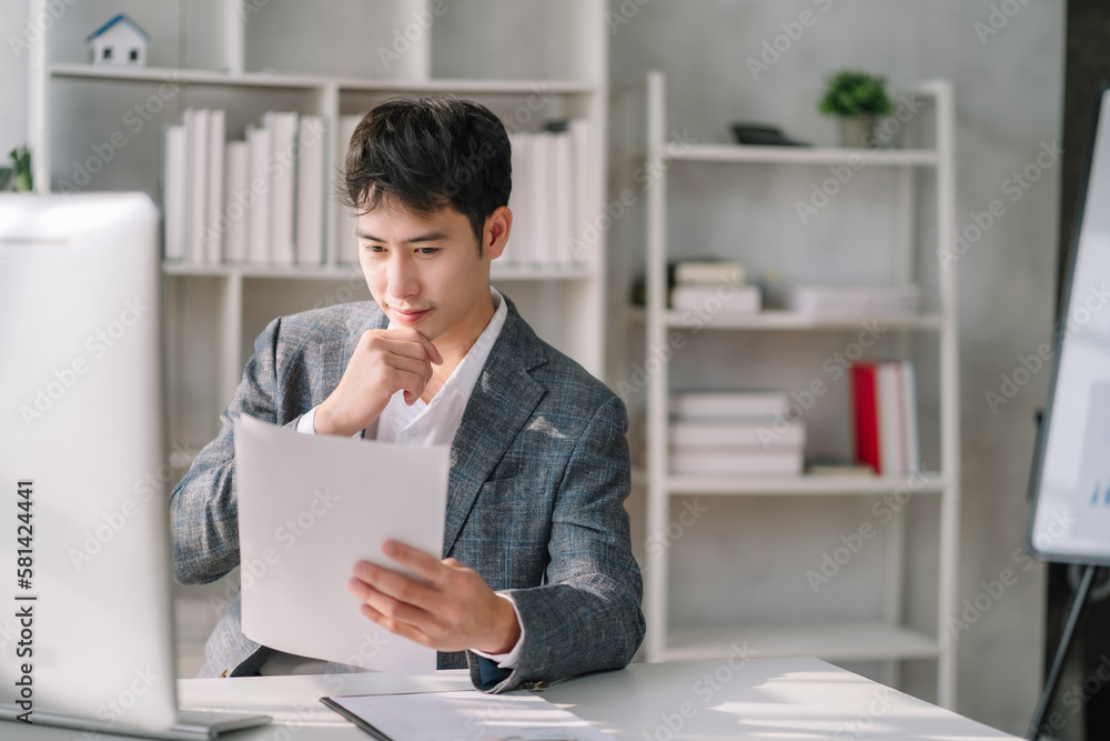 Business man asian working at office with laptop and documents on his desk, financial adviser analyzing data. Business man asian working at office with laptop and documents on his desk, financial adviser analyzing data.