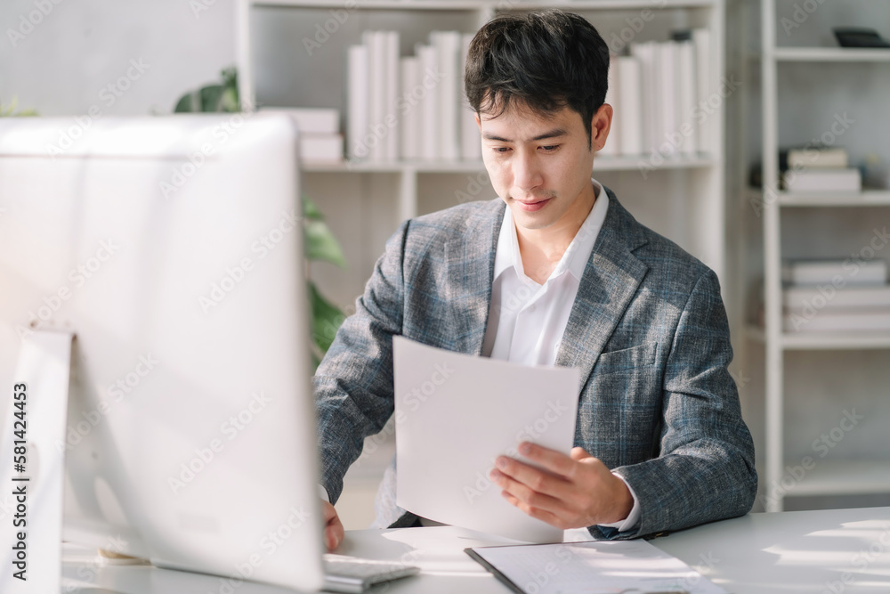 Business man asian working at office with laptop and documents on his desk, financial adviser analyzing data. Business man asian working at office with laptop and documents on his desk, financial adviser analyzing data.