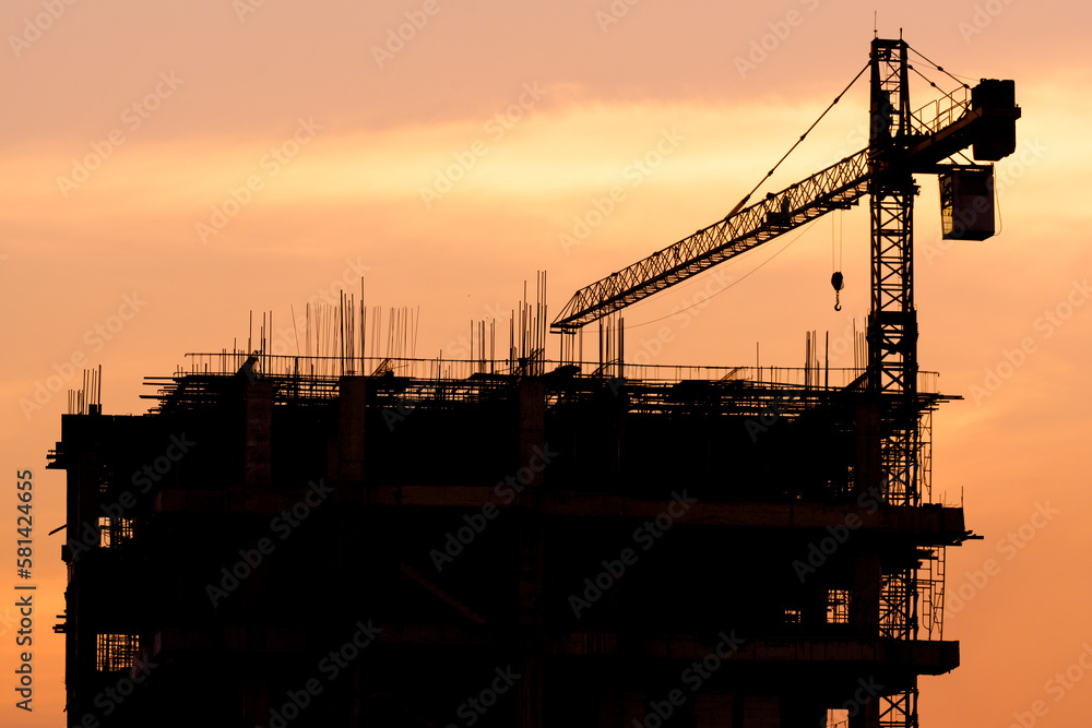 Silhouette construction site on sunset in evening time.Engineer and worker on building site.Construction sites and cranes are working in the industry new building business.