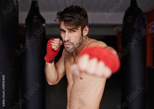 Want some of this. Portrait of a young boxer in a gym ready to spar. © Mikolette M/peopleimages.com