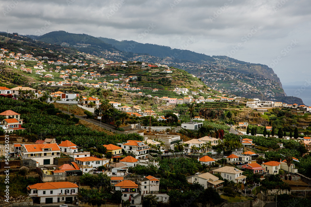 Houses with red roofs on the slopes of the mountains of Madeira island in the Atlantic ocean.