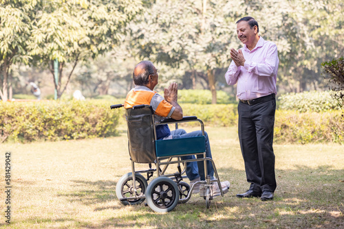 Senior friends meeting in a park and greeting each other, disabled person, wheelchair © G-images