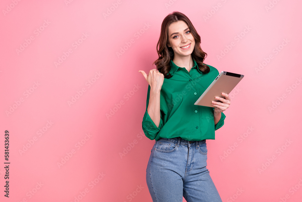 Photo of attractive pretty lady hold tablet indicate finger empty space isolated on pink color background Photo of attractive pretty lady hold tablet indicate finger empty space isolated on pink color background