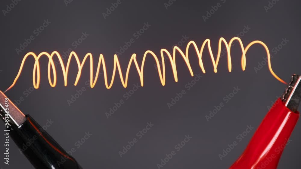 Nichrome filament connected to power wires is heated to red under the