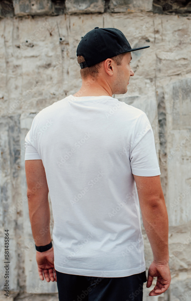 Young guy wearing white blank t-shirt and black cap. Mock-up for print. T-shirt template.