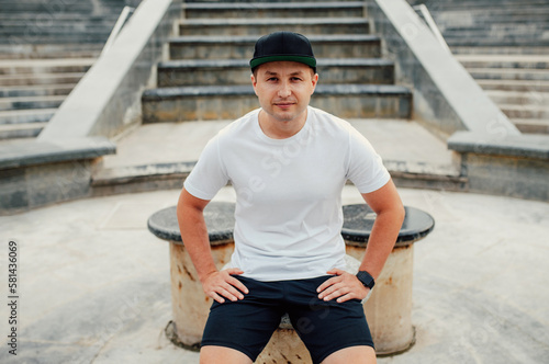 Young guy wearing white blank t-shirt and black cap. Mock-up for print. T-shirt template.