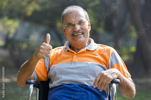 Photography Senior man on wheelchair and thumb up at park.