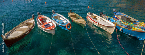 Billede på lærred Seven wooden boats are lined up in the sea in Manarola, Cinque Terre, Italy