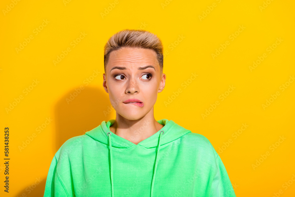 Portrait of puzzled minded lady biting lips look interested empty space isolated on yellow color background - obrazy, fototapety, plakaty 