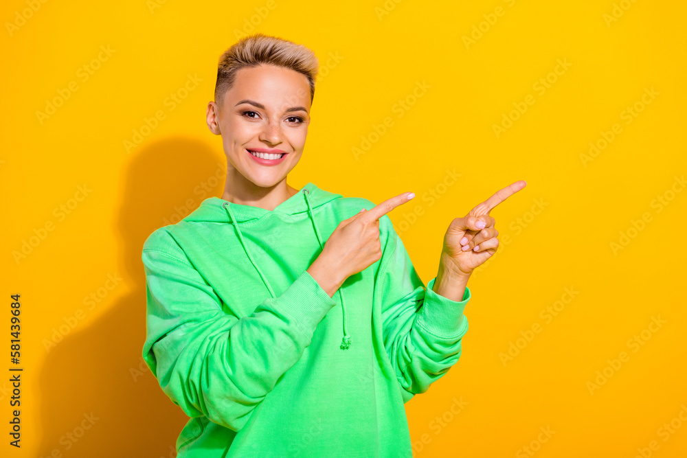 Portrait of gorgeous satisfied lady beaming smile indicate fingers empty space isolated on yellow color background Portrait of gorgeous satisfied lady beaming smile indicate fingers empty space isolated on yellow color background