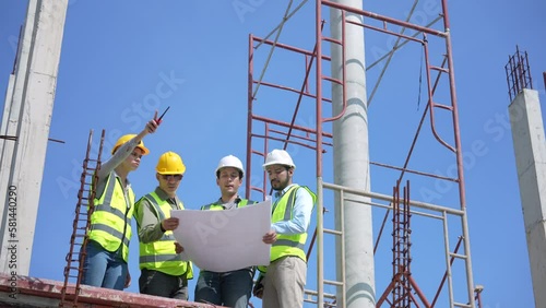 Construction engineer discussing and making plans with architect at construction site.