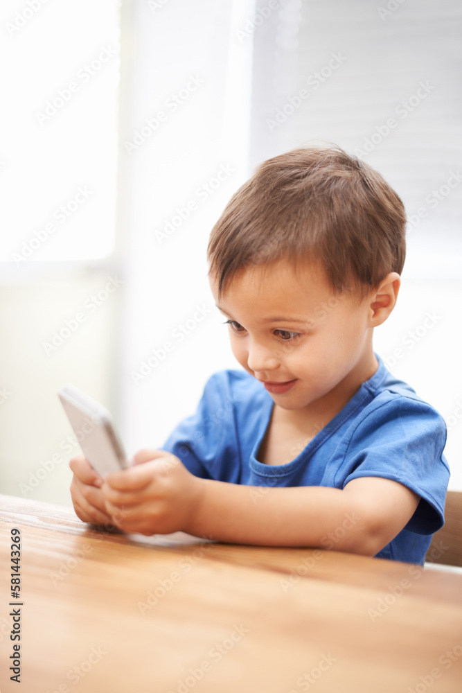 Discovering the world of technology. a mischievous boy playing with a cellphone. Discovering the world of technology. a mischievous boy playing with a cellphone.