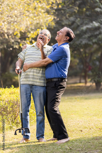 Two happy senior male friends spending leisure time at park