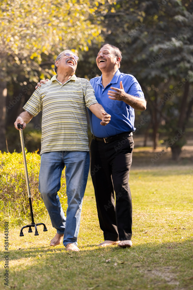 Obraz premium Two happy senior male friends spending leisure time at park
