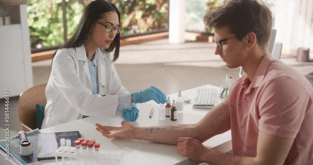 Young Asian Allergist is Conducting a Prick Scratch Test to Diagnose Any Allergic Reaction on a Young Male's Forearm During a Health Check Visit to a Medical Clinic. Female Doctor Working in Hospital Young Asian Allergist is Conducting a Prick Scratch Test to Diagnose Any Allergic Reaction on a Young Male's Forearm During a Health Check Visit to a Medical Clinic. Female Doctor Working in Hospital