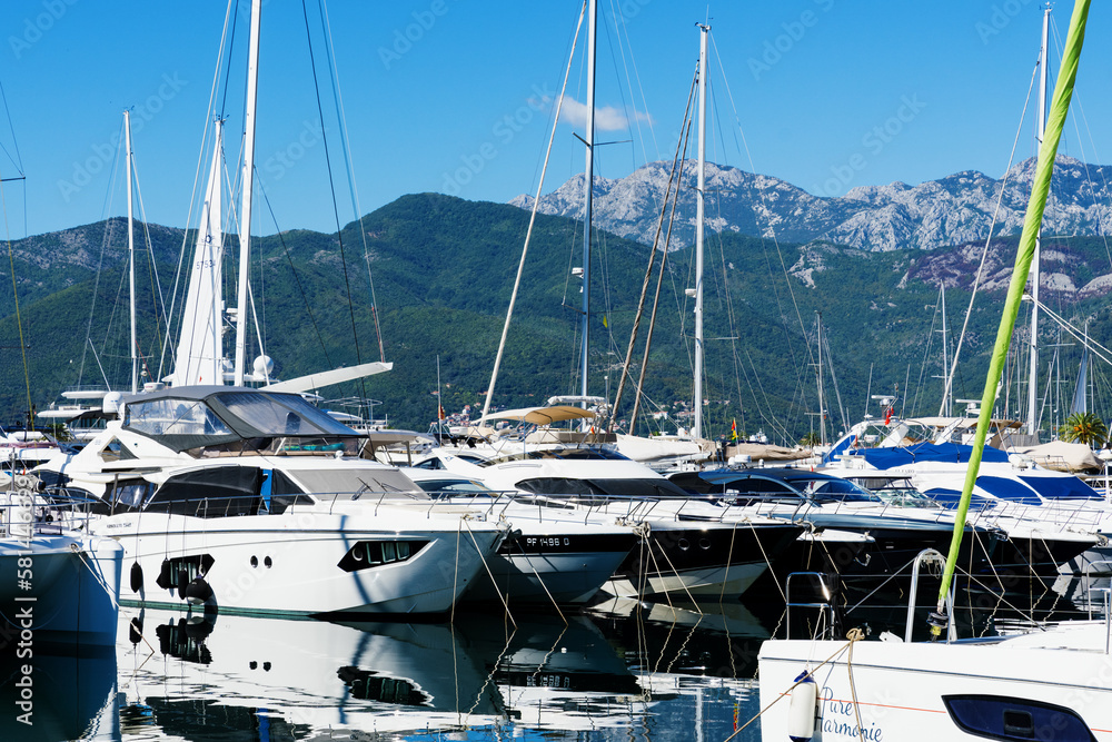 Tivat, Montenegro - February 15, 2023: Expensive boats stand in the marina in good weather against the backdrop of mountains