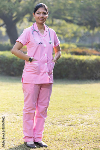 Photography Portrait of smiling nurse wearing uniform standing at park