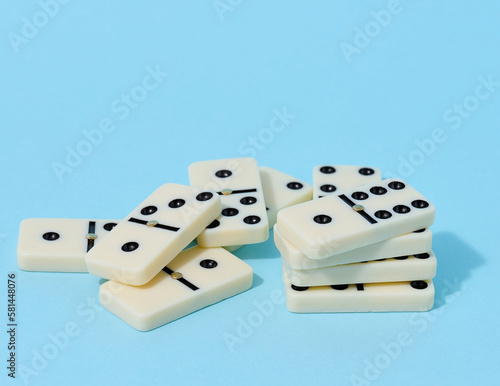 Fotografie A stack of dominoes on a blue background, an intellectual game