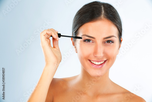 Stretching them for a night out. Studio portrait of an attractive young woman applying mascara to her eyelashes.