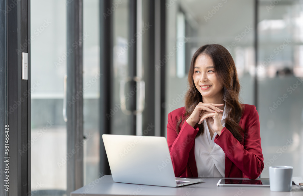 Beautiful Asian businesswoman working on a laptop computer doing financial, accounting analysis, reports, and data at the office. Beautiful Asian businesswoman working on a laptop computer doing financial, accounting analysis, reports, and data at the office.
