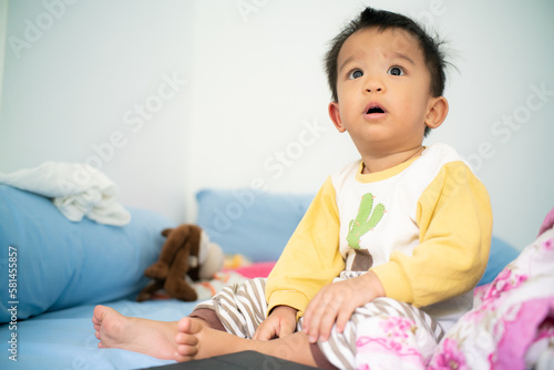 Toddler asian boy wake up on bed in cozy room
