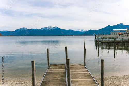 View of the Alps.Alpine lake.Lake near the mountains.Snow in the mountains.Wooden pier.Pier at the lake.Travel agency.Holidays in Germany.Popular tourist destination in Germany.Ship at the pier.Lake.