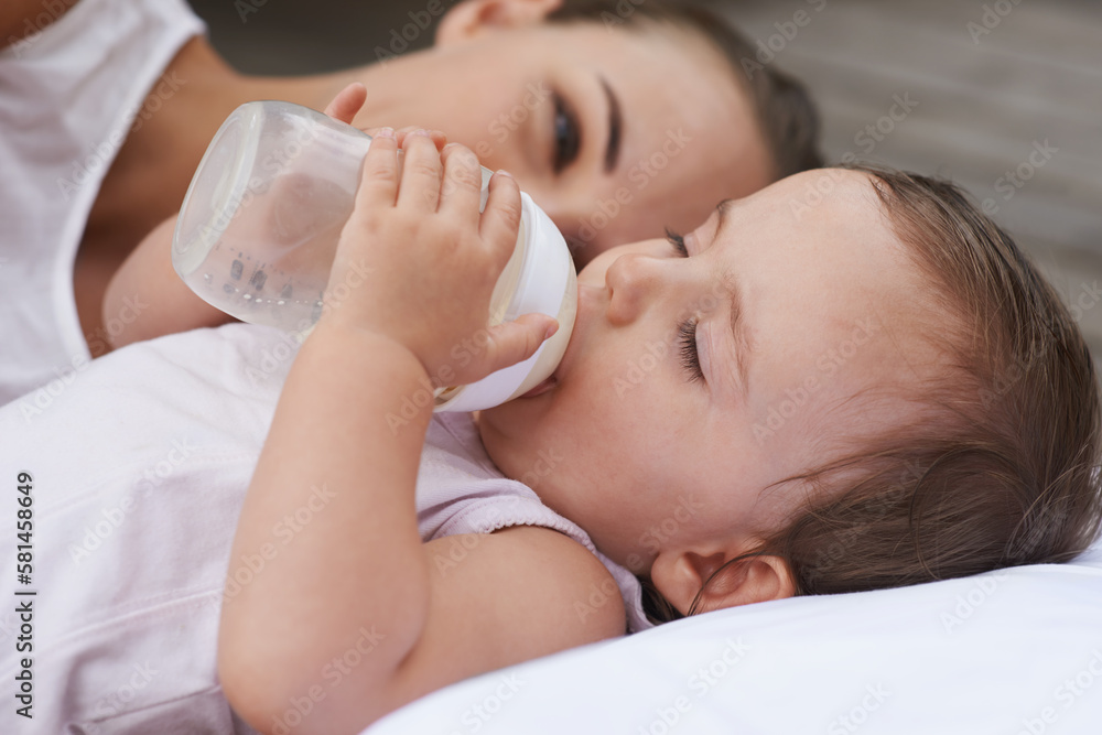 Keeping baby healthy. A mother looking on lovingly as her baby drinks from a bottle. Keeping baby healthy. A mother looking on lovingly as her baby drinks from a bottle.
