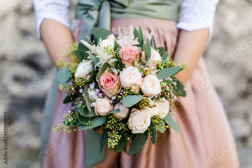 Braut im Dirndl h  lt Brautstrau  