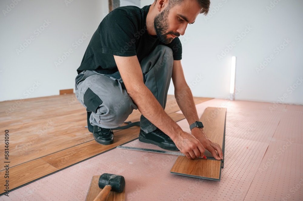 Hand work. Man is installing new laminated wooden floor Hand work. Man is installing new laminated wooden floor
