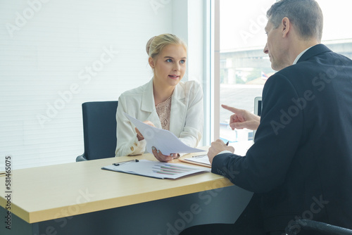 Professional business boss talking with secretary in modern office with waindow