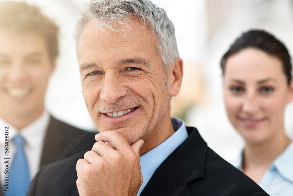 I have the best team behind me. Portrait of a mature businessman with colleagues standing in the background. I have the best team behind me. Portrait of a mature businessman with colleagues standing in the background.