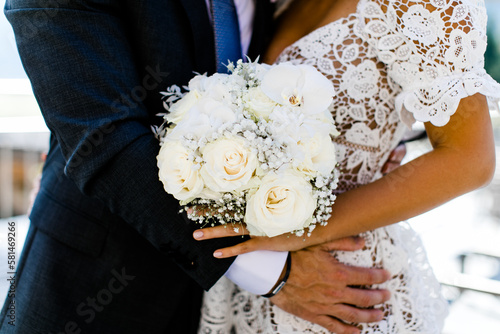 Brautpaar mit weißem Brautstrauß bei Hochzeit photo