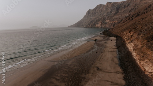 Sandy beach with rocky formations and sea photo