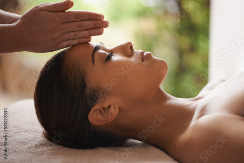 Massaging the body and mind. a beautiful young woman getting a head massage at a spa.