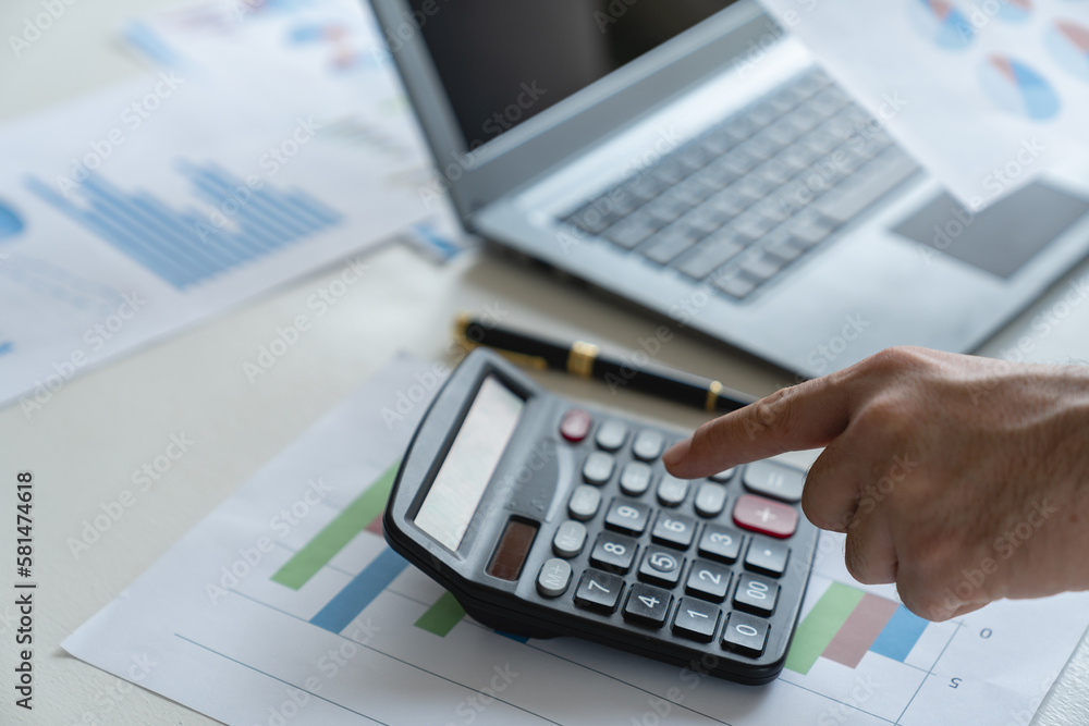 Young businessman analyzing Calculate with investment calculator, income, tax, account from data graph. Financial income in real estate projects View earnings on laptop at office desk. Young businessman analyzing Calculate with investment calculator, income, tax, account from data graph. Financial income in real estate projects View earnings on laptop at office desk.