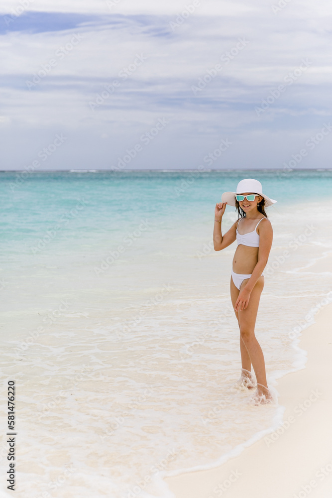 Mädchen im weißen Bikini am Strand im Urlaub im Paradies auf den Malediven Mädchen im weißen Bikini am Strand im Urlaub im Paradies auf den Malediven