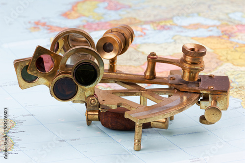 Fotografía nautical sextant with optics lying on paper world map