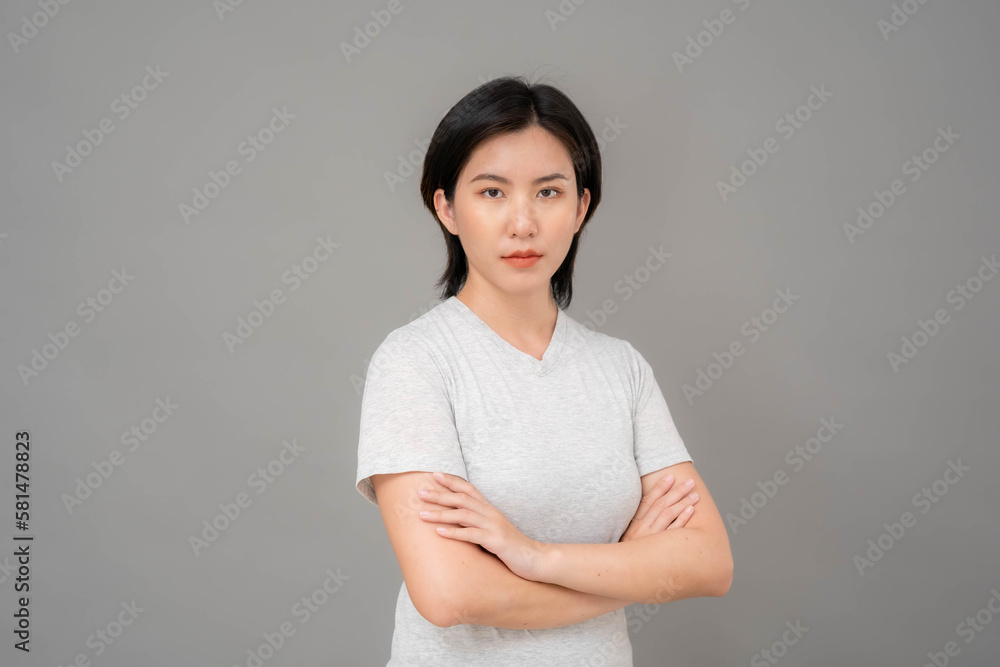 Portrait. A photo of an Asian woman standing with her arms folded in a stern look. Portrait. A photo of an Asian woman standing with her arms folded in a stern look.