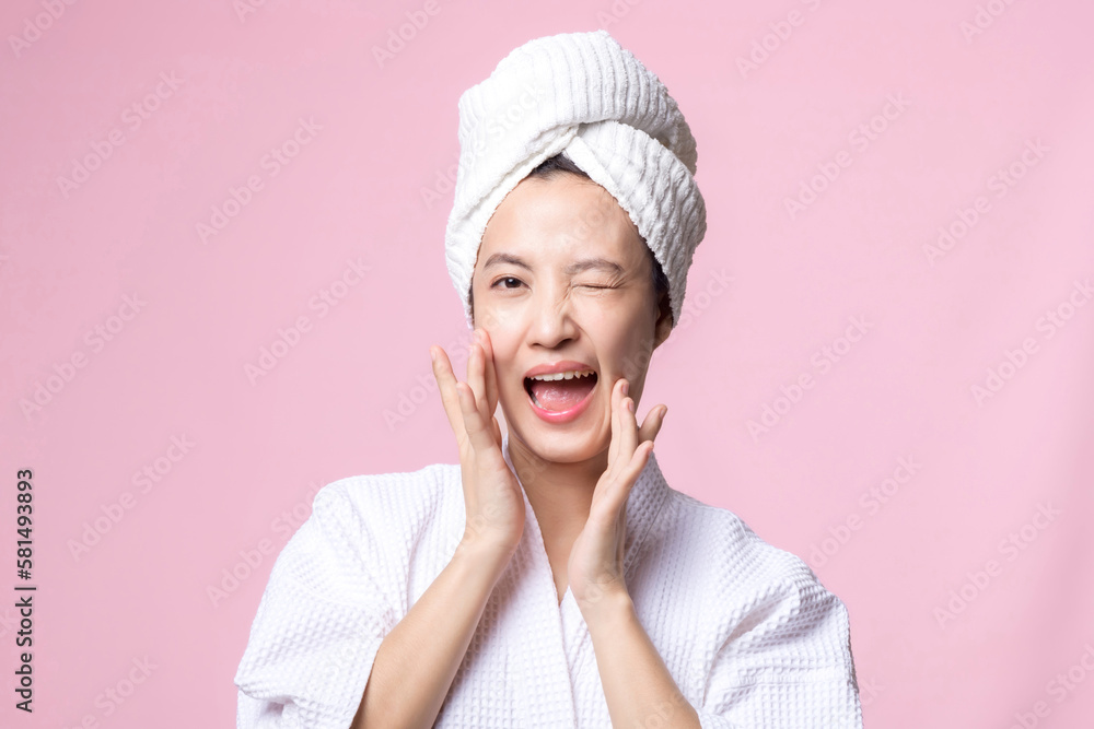 Beautiful young asian woman happy with clean face skin in towel and bathrobe, spa suit on pink background. Skincare, treatment, wellness therapy, facial care, beauty female health, cosmetology concept Beautiful young asian woman happy with clean face skin in towel and bathrobe, spa suit on pink background. Skincare, treatment, wellness therapy, facial care, beauty female health, cosmetology concept