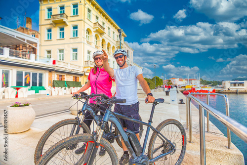 Active couple riding an E-Bike during vacations in the south © mmphoto