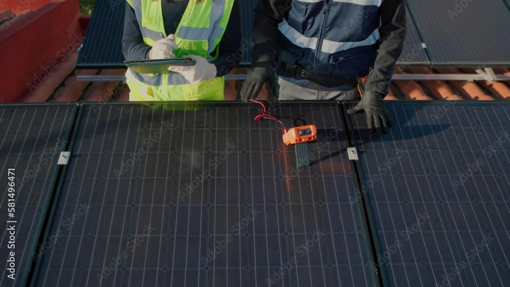 Cropped engineers on roof for solar panels maintenance, inspection, installation Cropped engineers on roof for solar panels maintenance, inspection, installation
