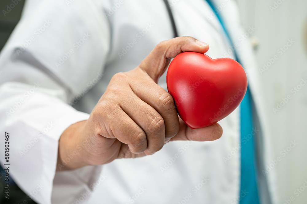 Doctor holding a red heart in hospital ward, healthy strong medical concept. Doctor holding a red heart in hospital ward, healthy strong medical concept.