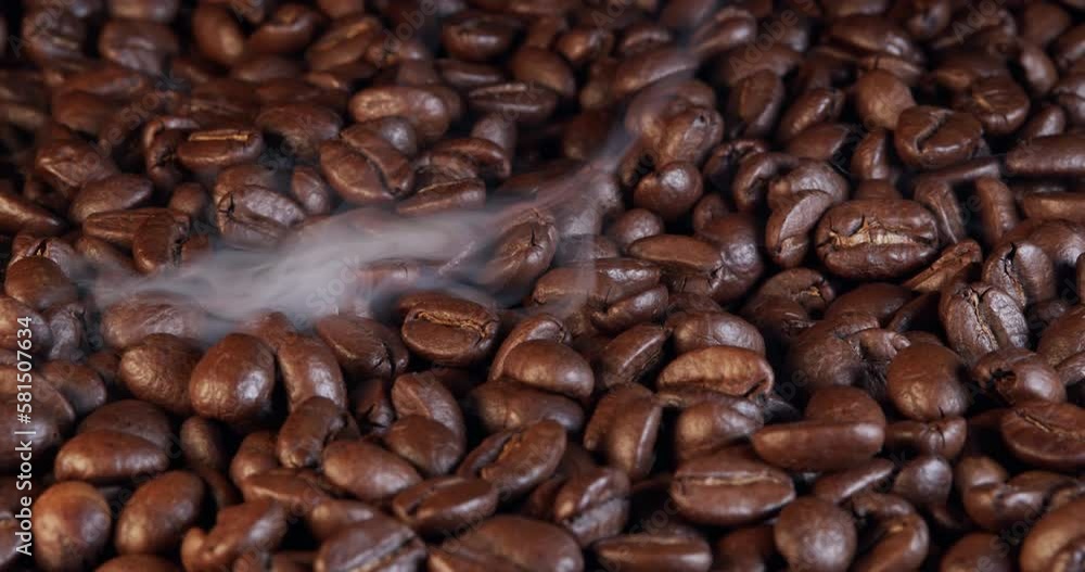 Roasting coffee beans with smoke on dark background, close up arabica robusta colombian beans. Roasting coffee beans with smoke on dark background, close up arabica robusta colombian beans.
