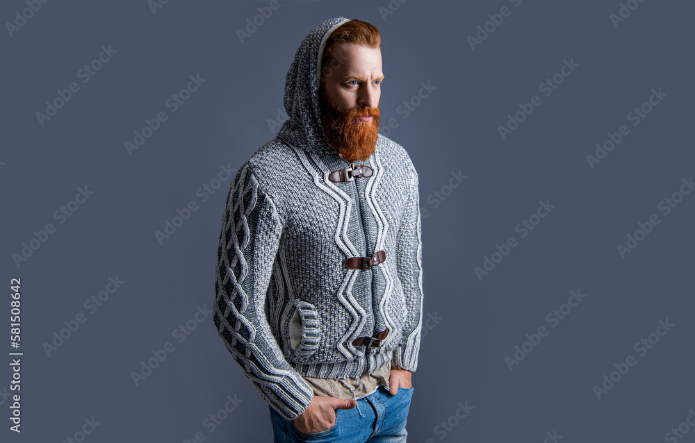 brutal man in warm knitwear with hood on background. photo of brutal man in warm knitwear.