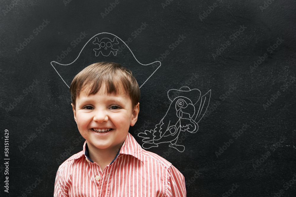 Drawing is so fun. Studio shot of an adorable little boy with chalk drawings behind him.